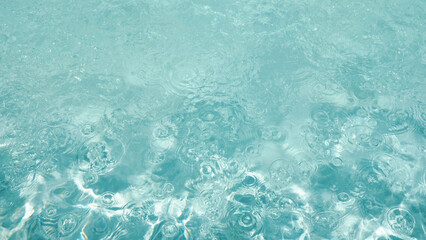 Abstract water background with ripples. Light caustics effect. Play of light and shadow, texture of twaves and splashes.