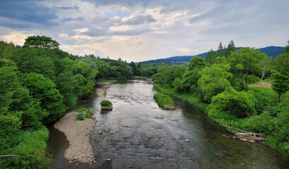 Krajobraz lata, zieleń i rzeka San, pochmurne niebo. Bieszczady. © Adam Sadlak