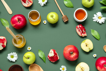 Frame made of fresh fruits honey and flowers on green background. Rosh hashanah (Jewish New Year) celebration