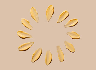 Cosmetic smear of cream texture in the form of rays of the sun on a beige background. Sunscreen cream.