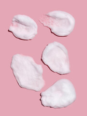 Texture of foam or mousse strokes on a pink background. Soap, shower gel, foam shampoo. Skin care. View from above.