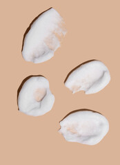 Texture of foam or mousse strokes on a beige background. Soap, shower gel, foam shampoo. Skin care.