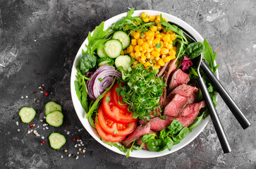 Beef steak and Fresh Vegetables Buddha Bowl, Healthy Balanced Meal on Dark Background