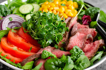 Beef steak and Fresh Vegetables Buddha Bowl, Healthy Balanced Meal on Dark Background