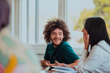 A group of diverse students engages in lively discussion as they educate themselves in a modern classroom, embracing the power of collaboration and knowledge exchange.