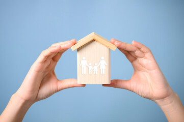 Hands holding wooden house with virtual family, Father mother and children with health care and life insurance, Family protection, Family home lifestyle