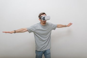 Futuristic man wearing virtual reality glasses interacts with the air in an isolated gray...