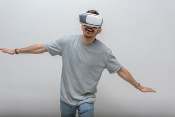 Futuristic man wearing virtual reality glasses interacts with the air in an isolated gray...