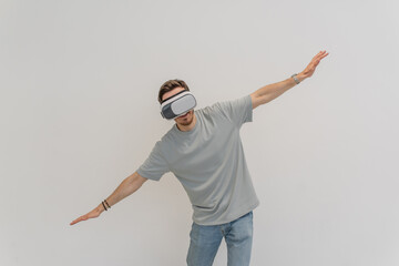 Futuristic man wearing virtual reality glasses interacts with the air in an isolated gray...