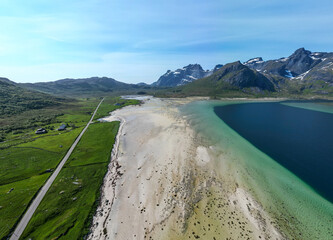 une longue route droite le long d'une plage sauvage au pied des montagnes norvégienne