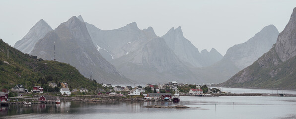 panorama sur un village scandinave au bord de l'eau et au pied d'une chaine de montagne abruptes