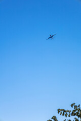 View of airplane flying in blue sky. Vertical photo. High quality photo