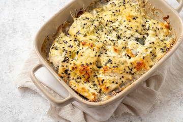 White fish casserole with cheese, sour cream and onion