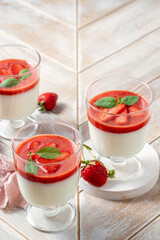 Italian dessert panna cotta in glass with strawberries.