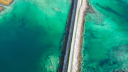 vue aérienne sur une route  qui traverse des eaux vertes et transparente