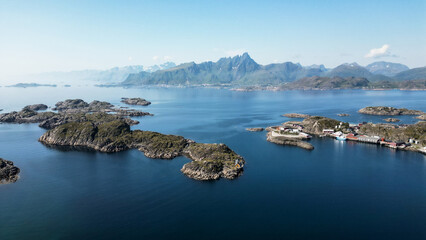 vue aérienne sur des îlots , des îles , un village , une chaine de montagne au bord de l'océan en NOrvège