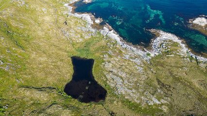 vue aérienne d'un petit lac de montagne et une mer bleue et verte en contre bas