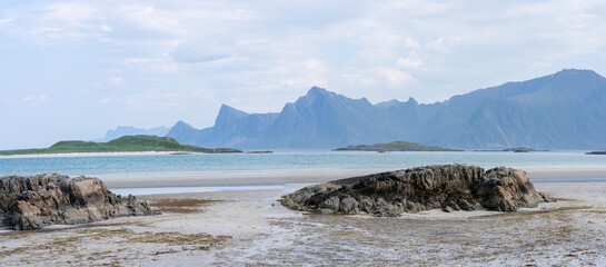 panorama sur une plage avec une chaine de montagne en arrière plan