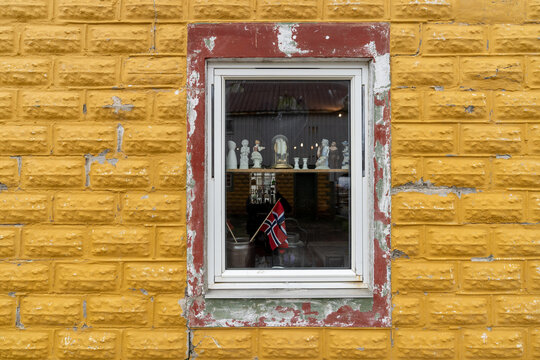 une fen&ecirc;tre sur un mur jaune , avec des objets et un fagnon norv&eacute;gien vu &agrave; travers 
