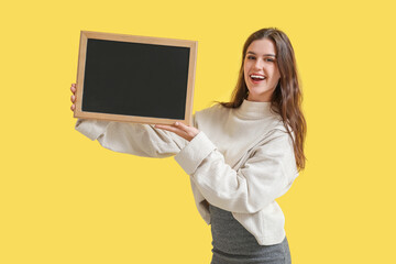 Female teacher with chalkboard on yellow background