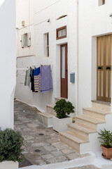 A beautiful view of a narrow street with clothes drying on a clothesline in Ostuni.