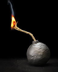 Round black bomb with lit fuse burning and smoking. Bomb about to detonate symbolizing destruction,...