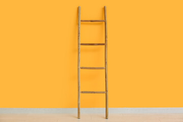 Wooden ladder near orange wall in room