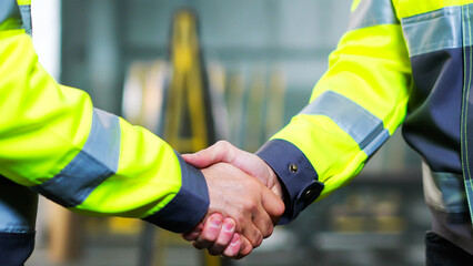 Close up of Caucasian men shaking hands at factory as sign of agreement and good work together....