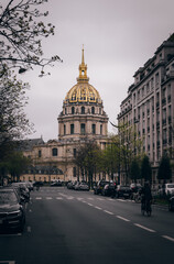 Fototapeta na wymiar A road with cars parked on the side of the road leading to the beautiful Cathedral Saint Louis des Invalides