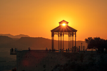 Ronda viewpoint kiosk, Malaga, Andalusia, Spain with tourists at sunset backlit