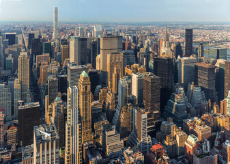 New York City Manhattan street aerial view with skyscrapers, pedestrian and busy traffic. Sun at sunset.