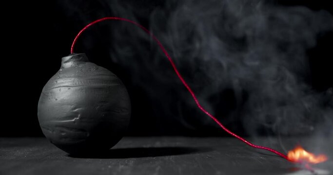 Round black bomb with lit fuse burning, sparking, and smoking. Bomb about to detonate symbolizing destruction, threats, or dangerous violence.