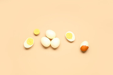 Tasty boiled eggs with halves on orange background