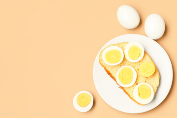Plate of toast with boiled eggs on orange background