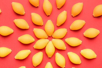 Uncooked pasta on red background