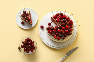 Plates with tasty cherry cake on yellow background