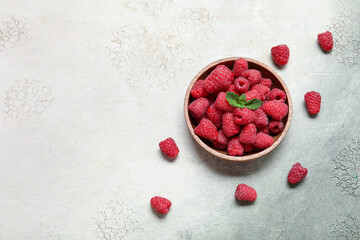 Bowl with fresh raspberry and mint on light background