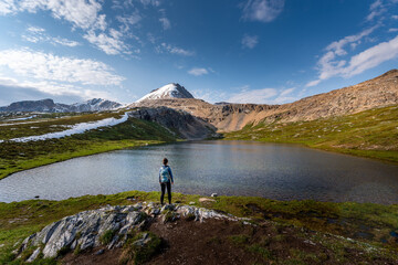 Fototapeta na wymiar Backpacker Girl admires beautiful Helen Lake and Cirque Peak Banff National Park Alberta
