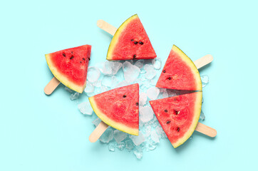 Sweet watermelon sticks and ice cubes on blue background