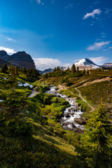 Naklejka premium Hiker crossing a footbridge on a Helen Lake trail with Cirque Peak in the background