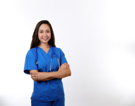 A friendly hispanic nurse wearing blue scubs and smiling at the camera.