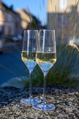 Tasting of premier cru sparkling white wine with bubbles champagne with view on old houses of...