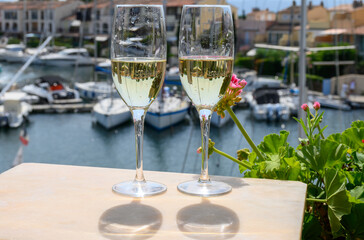Drinking of French brut champagne sparkling wine in glasses, club party in yacht harbour of Port...