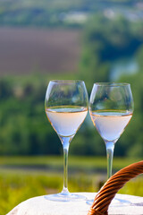 Tasting of premier cru sparkling rose wine with bubbles champagne with view on green pinot noir, meunier vineyards of Hautvillers, France.