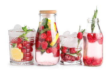 Glasses and bottles of fresh raspberry lemonade on white background
