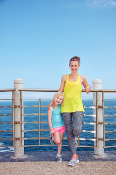 Look Good, Feel great! Full length portrait of happy mother and child in fitness outfit standing on embankment