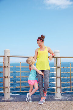 Look Good, Feel great! Full length portrait of happy mother and child in fitness outfit standing on embankment