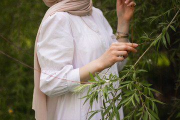 Portrait of A young Muslim woman in a white dress front of a tree. close plan. Pretty modest Muslim...
