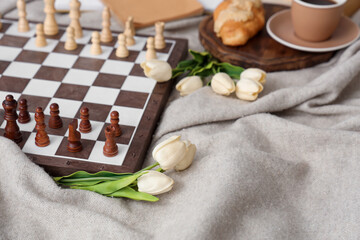 Chess board with tulips on plaid, closeup