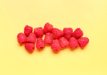 Many fresh raspberries on yellow background